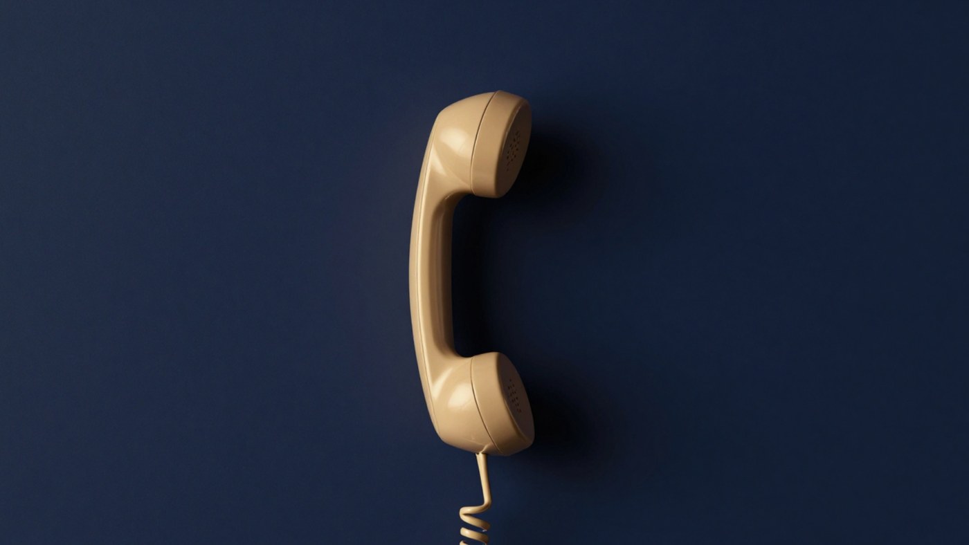 A telephone handset against a deep navy wall